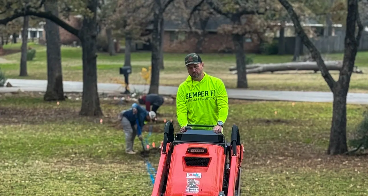 Owner Justin Holt running a trencher on a Semper Fi Landscape Solutions job in North Texas