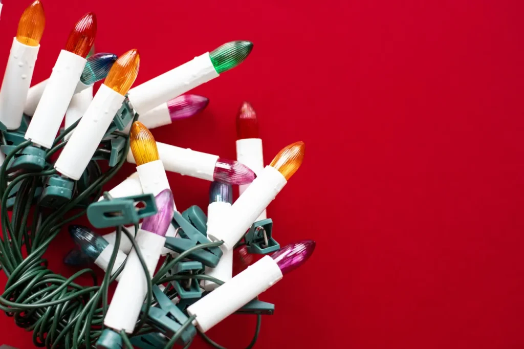 A coiled string of multicolored Christmas lights with mounting clips, ready to be installed